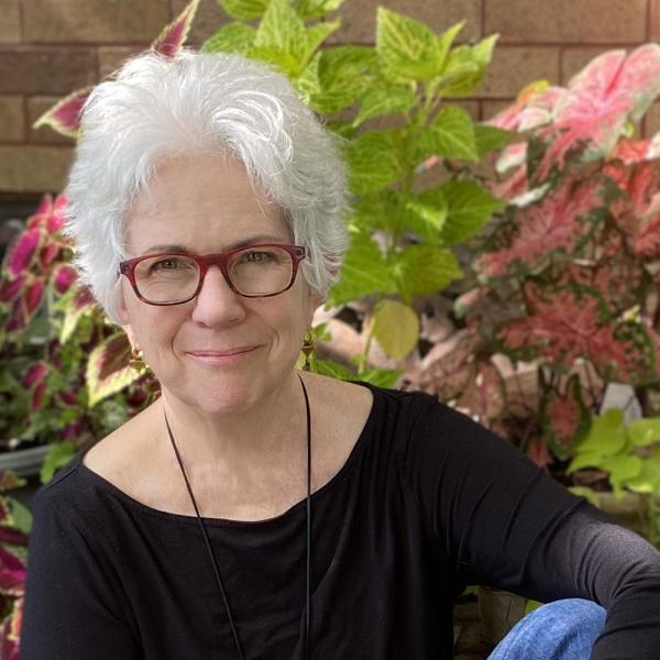 Photo of Terry Irwin, recipient of the 2021 AIGA Medal seated casually with a garden background