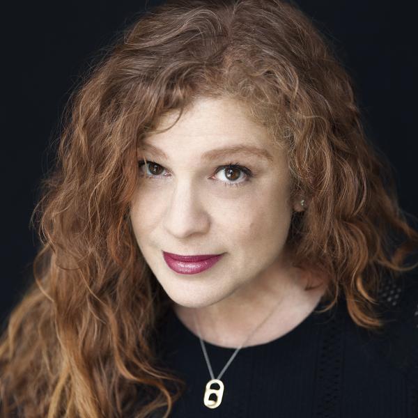 Headshot of 2022 AIGA Medalist Emily Oberman wearing a black top with a necklace against a black background. Image courtesy of Pentagram. Photo credit: ©: Jake Chessum